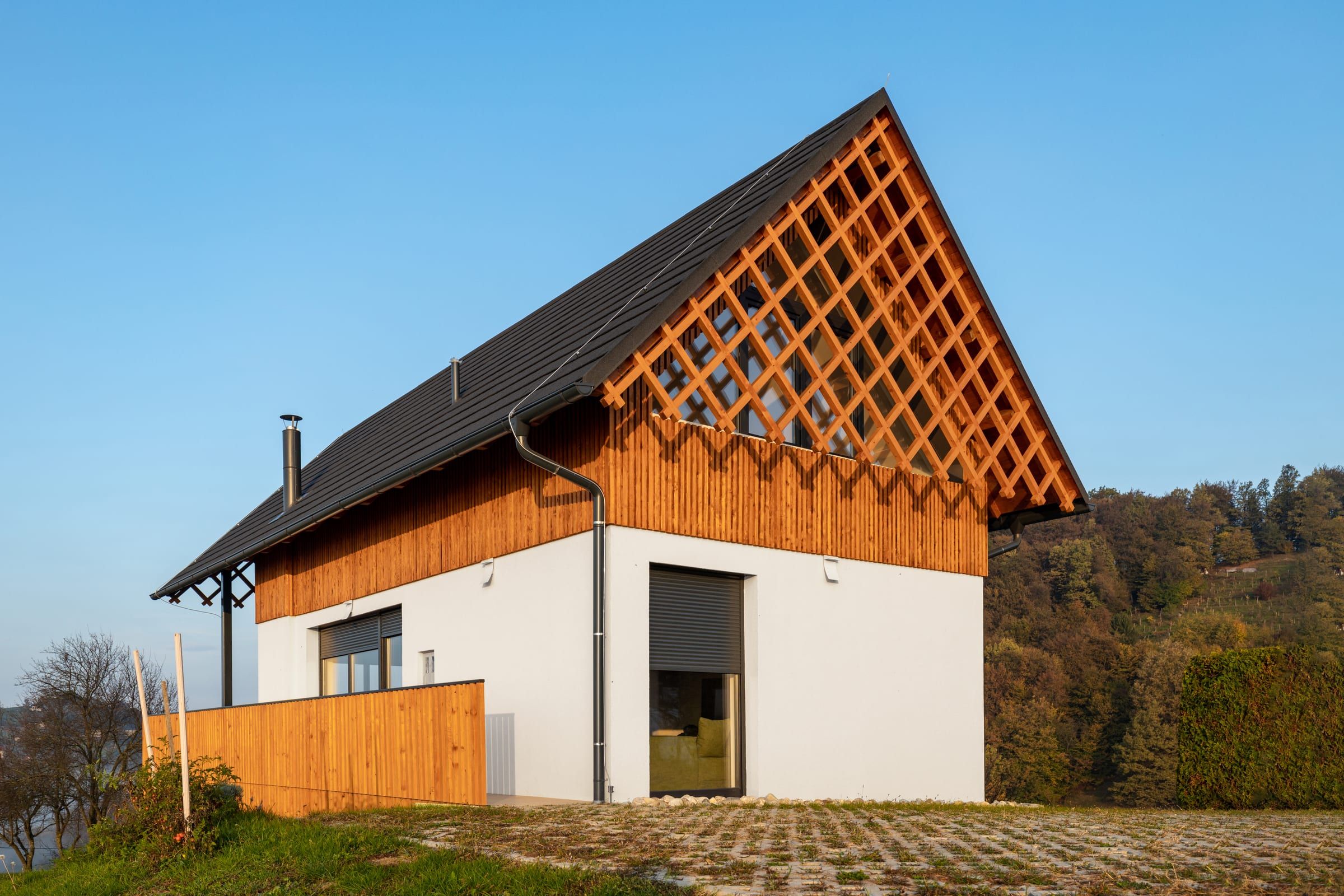Villa Strtenica's white and timber facade with its diamond-latticed gable on the hilltop.