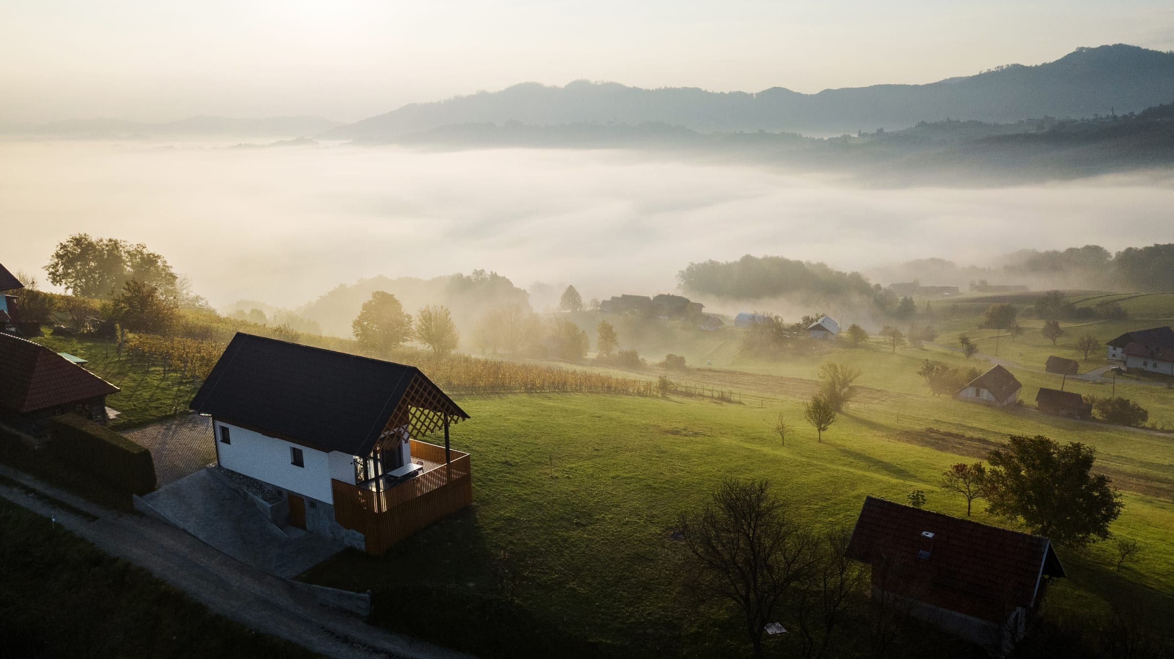 Aerial view of the fog-filled valley below the villa at sunrise.